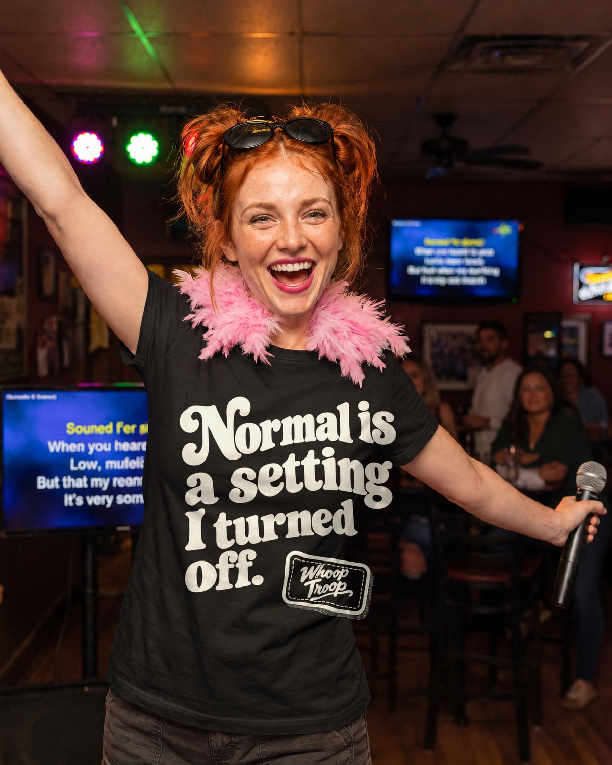 AI-generated image: a woman in a pink feather boa singing karaoke, wearing the black Normal is a Setting tee