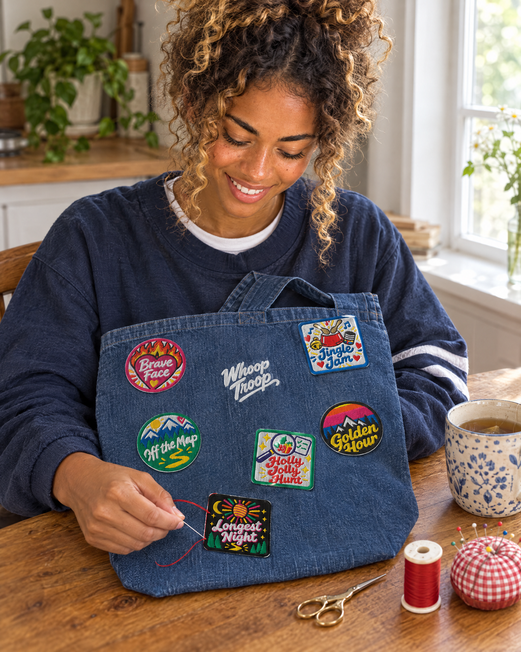 AI-generated image: a woman hand-sewing Whoop Troop badges onto the denim tote at her kitchen table
