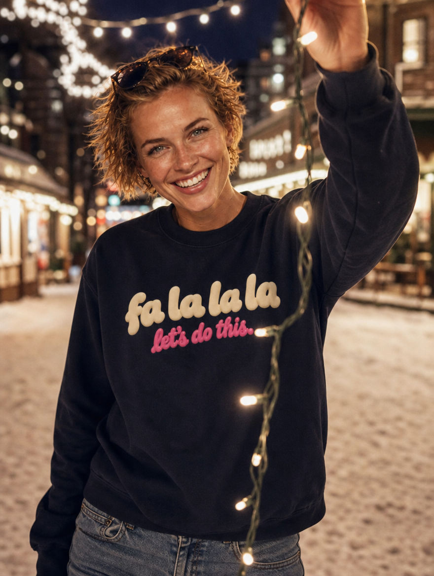 AI-generated image: a woman holding holiday lights on a snowy street in the navy Fa La La La, Let's Do This sweatshirt